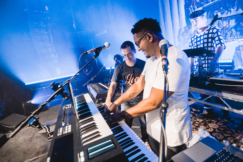 Kevin Randolph collaborating with another artist on stage while playing MONTAGE synthesizer.